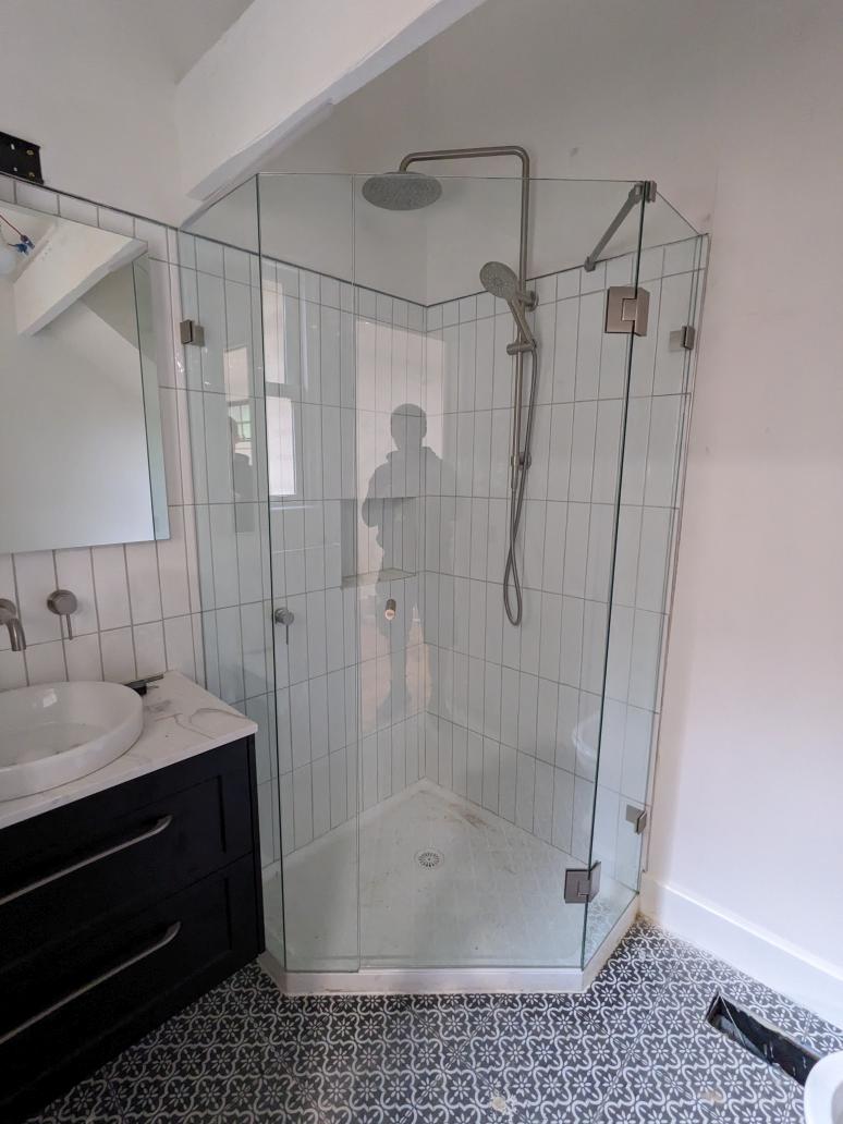 Frameless diamond shower screen with white tiles and compact bathroom layout