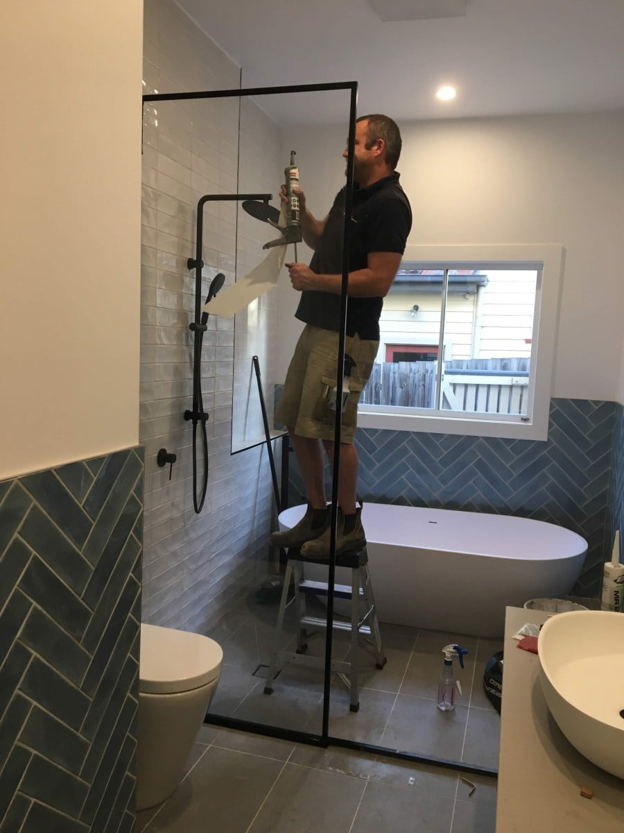 Shower screen installer doing silicone work