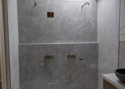 Wall to wall full height frameless shower screen with gold hardware