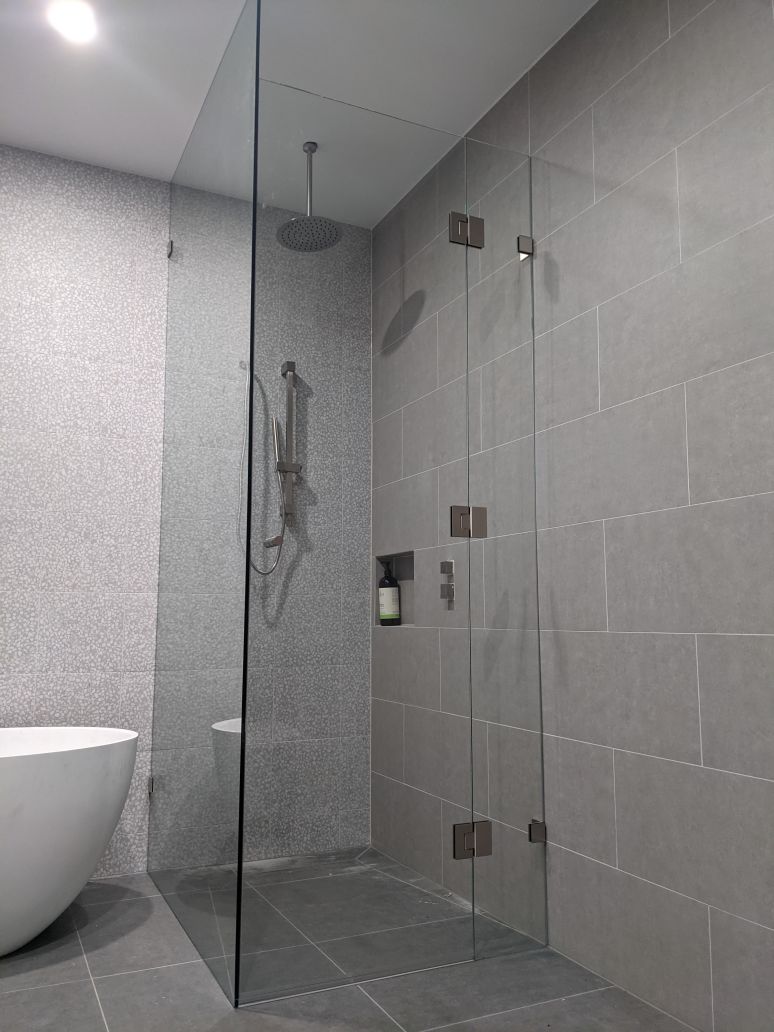 Frameless Corner shower screen with a full height return panel