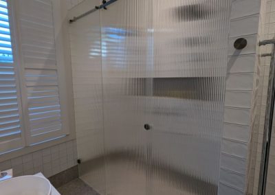 Frameless sliding shower screen with matte black hardware