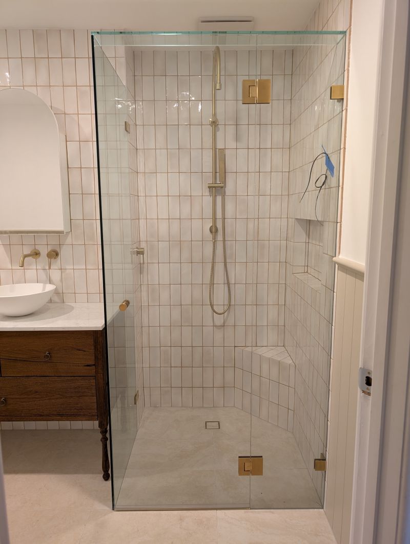 Frameless showerscreen with brushed gold hardware