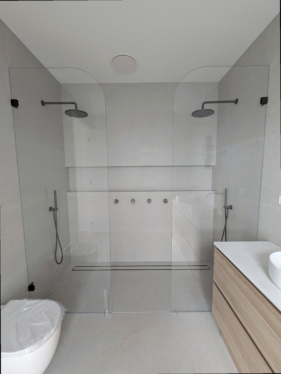 Walk in shower with curved glass panels on either side