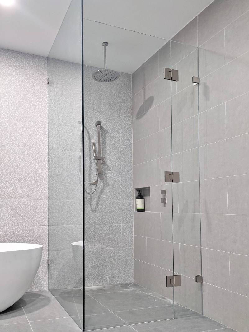 floor-to-ceiling-corner-shower-screen Full height frameless shower screen with dual shower heads and full width niche