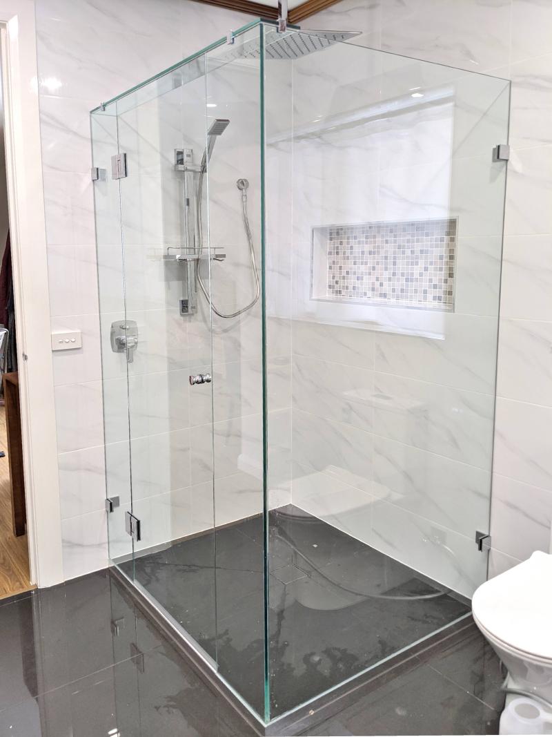 Frameles shower screen with marble look tiles