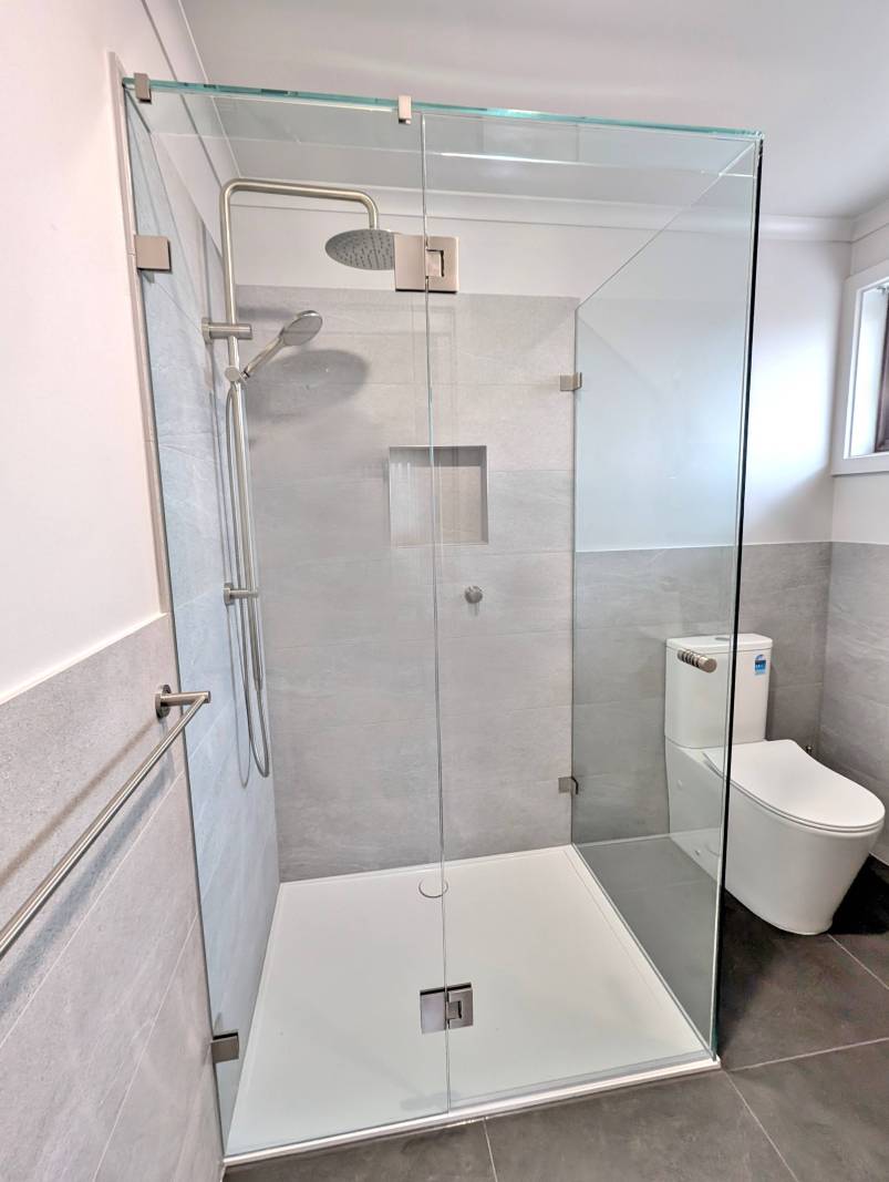 Frameless shower screen on white acrylic base