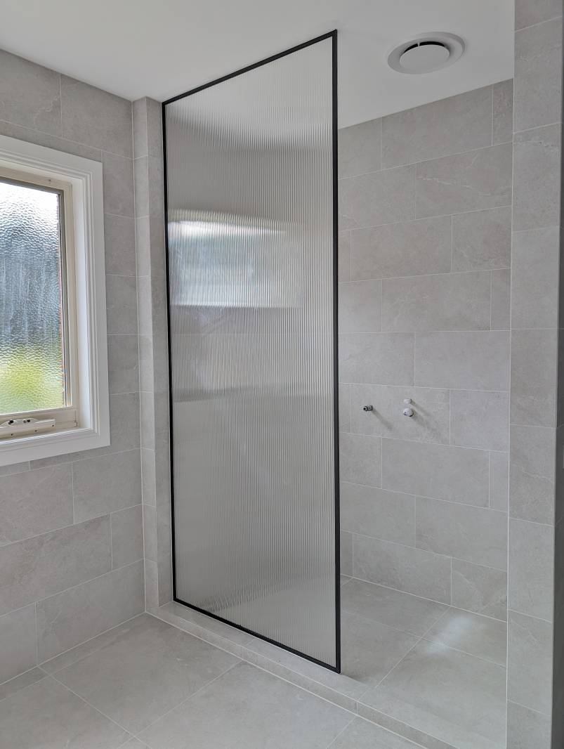 Full height fluted glass black frame shower screen panel