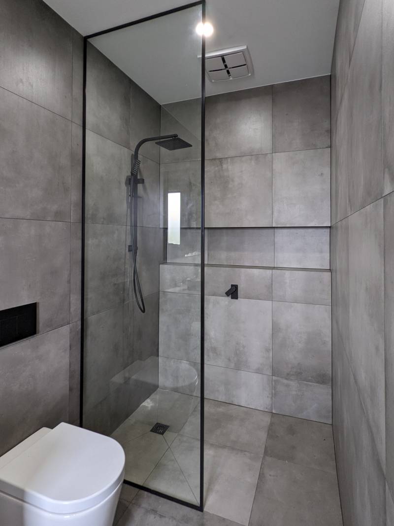 Full height black frame shower screen grey tiles to ceiling