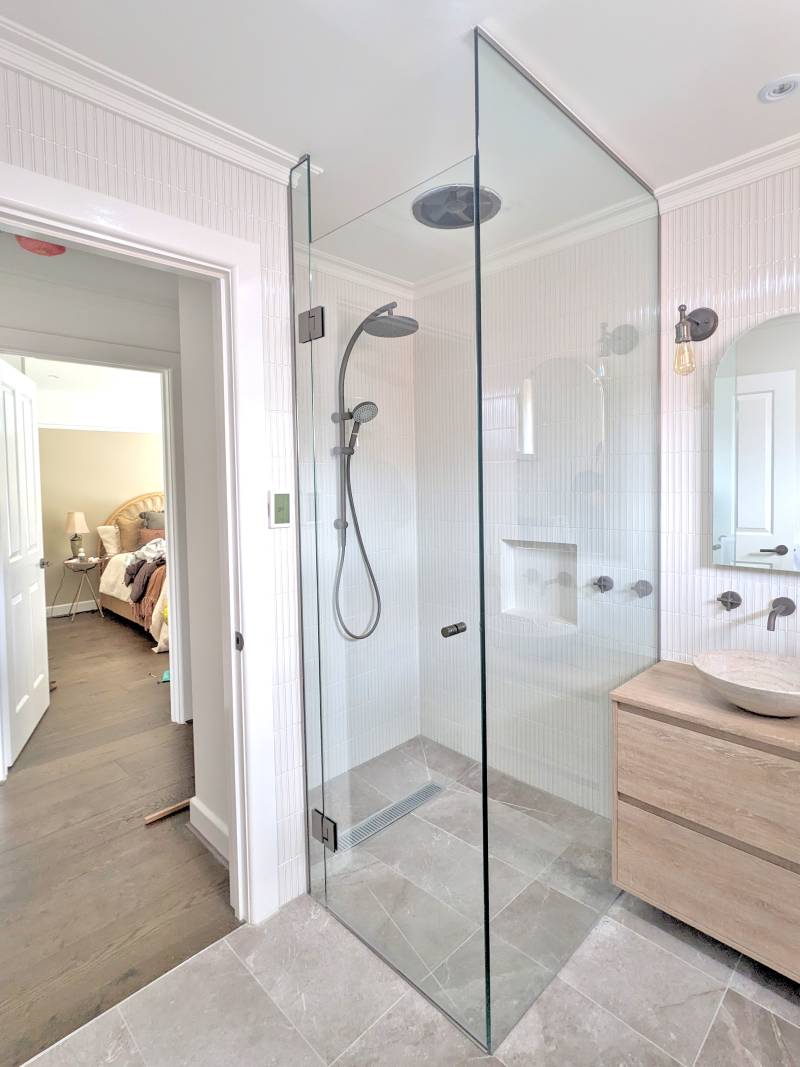 Full height frameless shower screen with gun metal hardware and timber look vanity