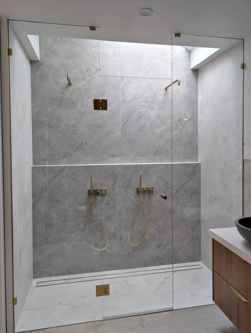 Full height frameless shower screen with dual shower heads and full width niche