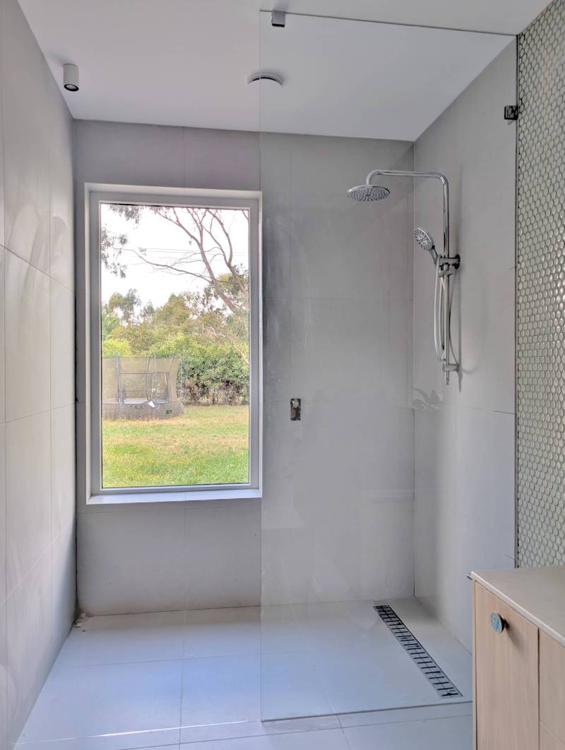 Walk in shower with a full height glass panel