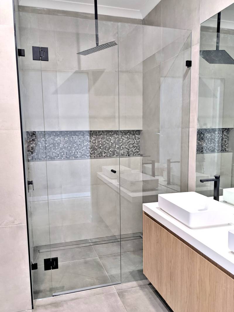 Wall to wall frameless shower screen with black hardware