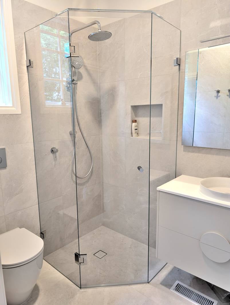 Low-iron frameless shower screen with floating vanity and chrome fittings