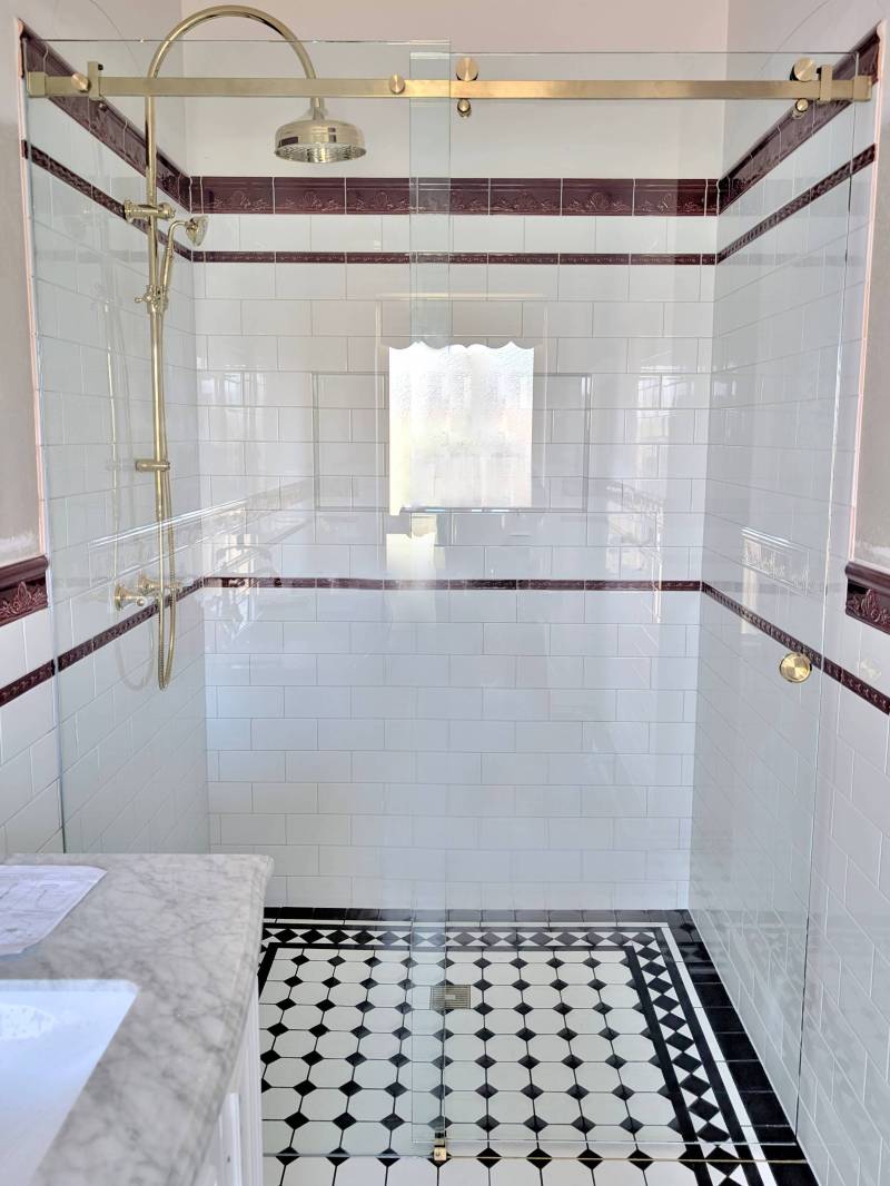 Wall-to-wall sliding shower screen with golds hardware in a Victorian style ensuite