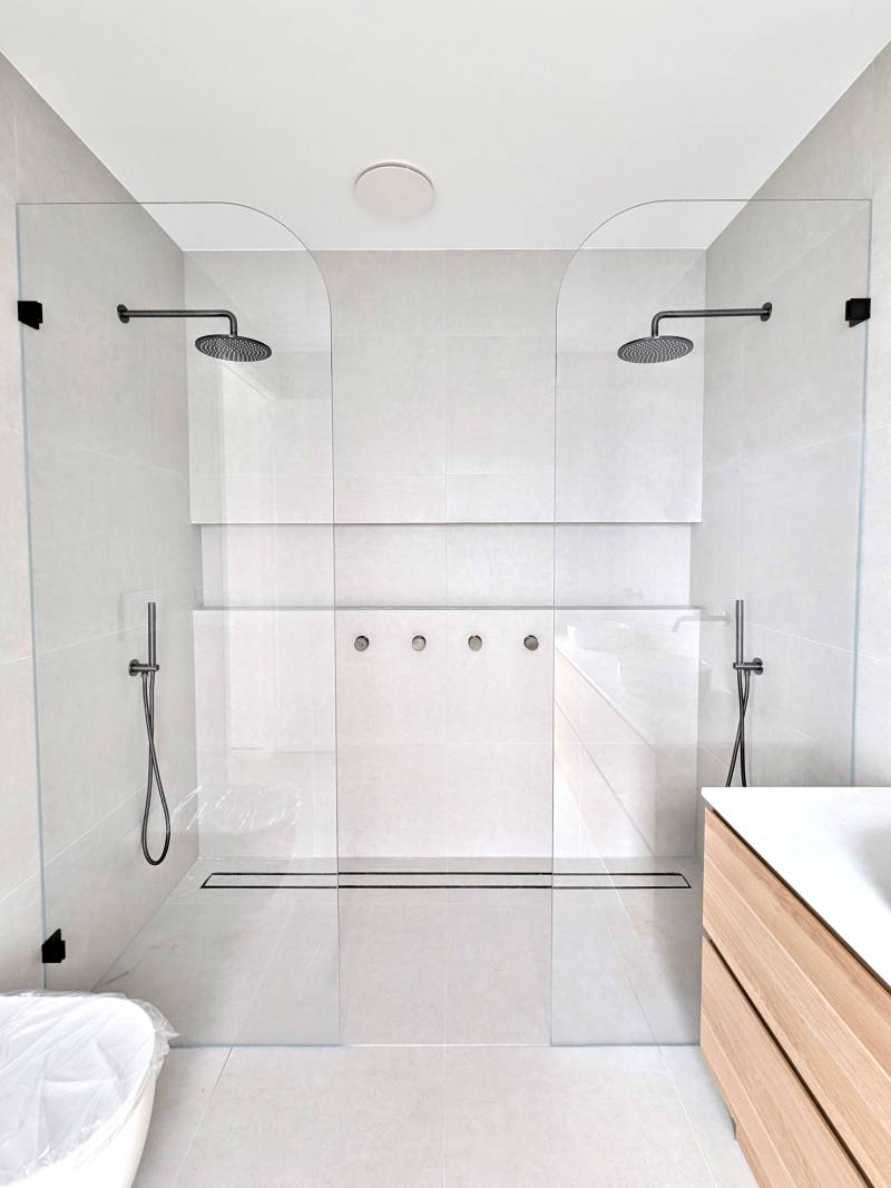 Ensuite double shower with a curved corner glass panel on either side