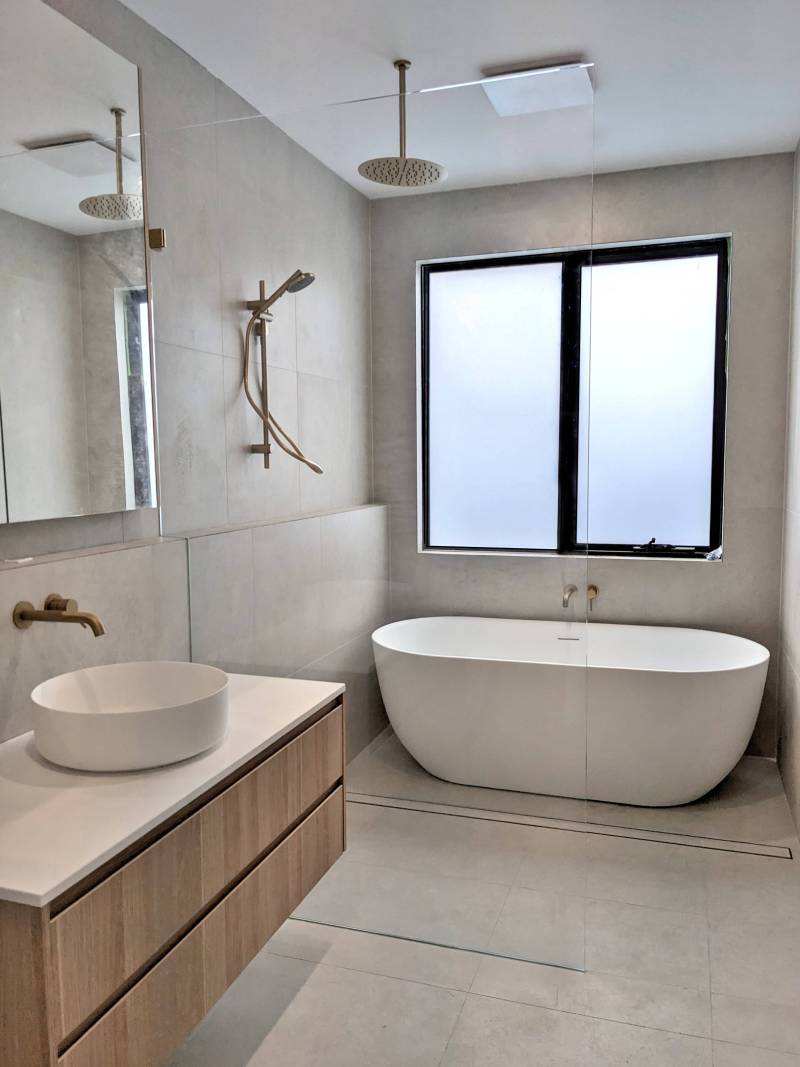 Walk in shower with a tall glass panel in a bathroom