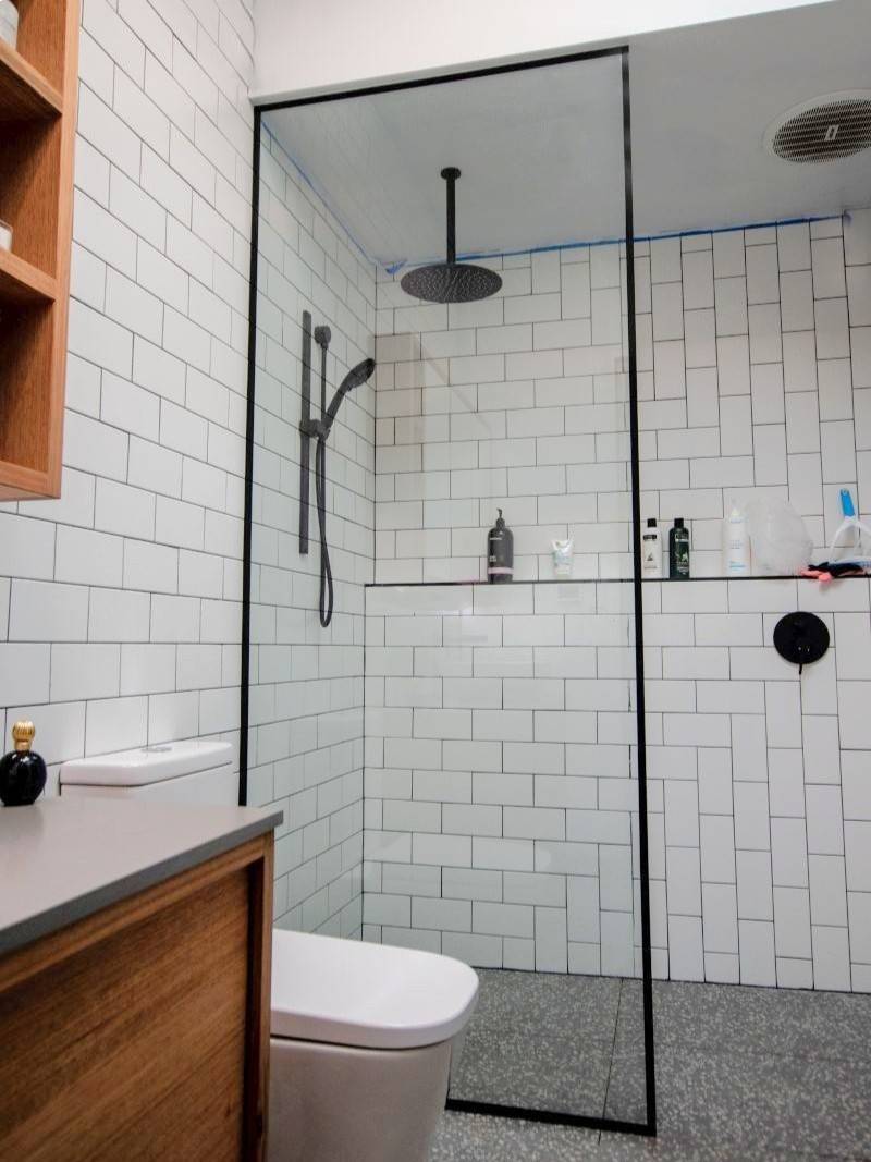 Floor-to-ceiling shower panel with a black frame all around
